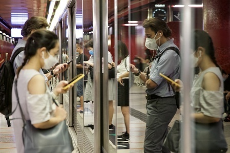 Passengers wearing face masks as a precautionary measure, waiting at the MTR platform during the covid 19 crisis.
7 days in a row of 3 digits infected cases and 15 people dead in Hong Kong. The government announced further restrictions to curb a surge in coronavirus cases, including a ban on gatherings of more than two people, a total ban on restaurant dining and mandatory face masks in all public places.