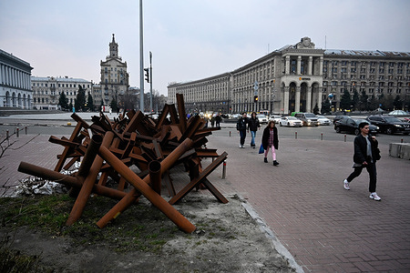 People pass anti-tank hedgehogs on Independence Square in Kyiv.