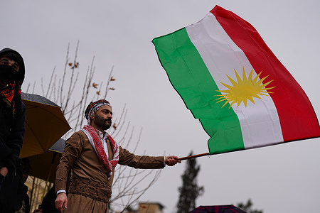A Kurdish man holds a national flag during a demonstration at Newroz Square in solidarity with the Kurdish people of Rojava (northeast Syria). Cities across the Kurdistan Region witnessed demonstrations condemning the recent military escalation and the siege imposed by Syrian regime forces on Kurdish-held areas in Rojava (northeast Syria). Waving Kurdish flags, demonstrators gathered in large crowds and called on the international community and the United Nations to intervene to protect civilians.