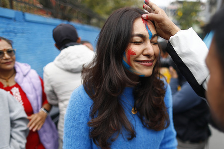 Supporters seen smearing colors on their faces as they celebrate the victory of Ranju Darshana a candidate of the Rastriya Swatantra Party (RSP) in Kathmandu-1 election.
