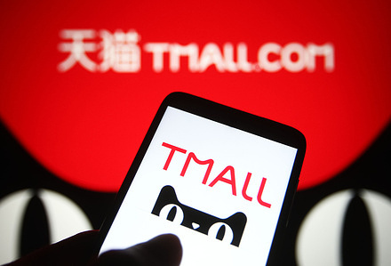 In this photo illustration, Tmall (Tmall.com) logo is seen on a smartphone and a pc screen.