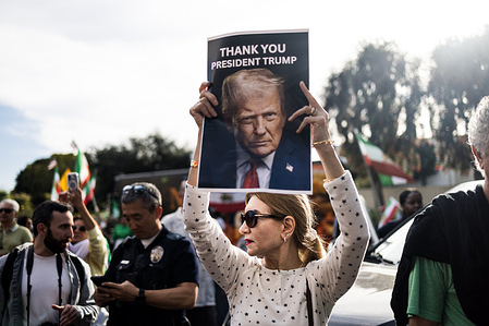 A woman holds a poster reading “Thank You President Trump” featuring an image of U.S. President Donald Trump during a rally in Los Angeles. The demonstration took place in Westwood where members of the Iranian diaspora assembled after the reported death of Ayatollah Ali Khamenei.