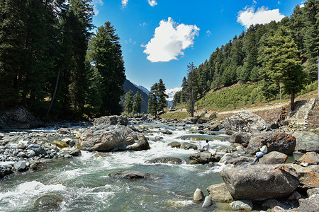 Indian tourists relax near the stream in Pahalgam, a famous tourist destination, about 120kms south of Srinagar, the summer capital of Jammu and Kashmir.