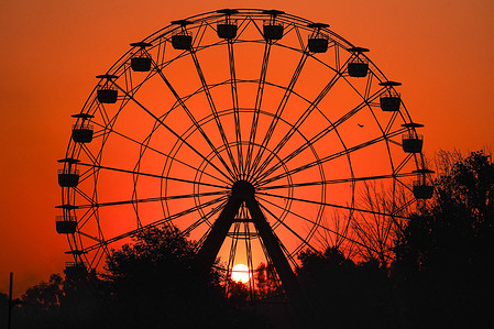 A view of Sunset behind a Ferris wheel in the city of Mosul, northern iraq.