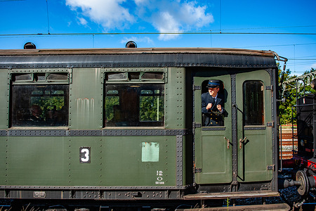 A train inspector is seen looking through one of the windows. Two large German steam locomotives, a Baureihe 50 and a Baureihe 23, travelled between Nijmegen and Den Bosch. The event was an initiative of Het Stoomgenootschap (The Steam Society) organization.