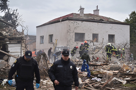 People and rescuers clear the rubble of a house after a direct hit by a Russian missile following a massive missile and drone attack on Lviv Following a massive missile and drone attack on Lviv by Russian forces, widespread destruction was seen across residential and industrial areas. A warehouse and several houses were reduced to rubble, sparking large fires as firefighters and rescuers worked to extinguish the flames and clear debris.