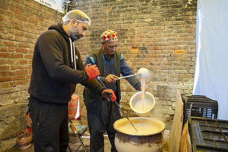 Nazir Ahmad, along with his son, seen preparing Phirni (a dessert) for sale at their workplace in Srinagar. Phirni is believed to have originated in Persia or the Middle East and was introduced to India by the Mughals, who popularized it in their royal kitchens. In Kashmir, Nazir Ahmad is one of the oldest phirni makers. He has been making this traditional dessert for the past 61 years, exclusively during Ramadan. Phirni remains the most consumed dessert during Ramadan in Kashmir.