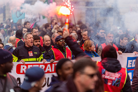 Demonstrators hold a banner during the protest. Thousands of French people gather and march on the streets of Paris on March 15, which marks the eighth general strike against the new Macron's pension reform.