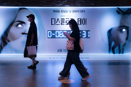 People walk past a billboard for Disclosure Day featuring a countdown to its release. Steven Spielberg’s upcoming sci-fi thriller Disclosure Day, starring Emily Blunt and Josh O'Connor, is set to make its early international theatrical debut in South Korea on June 10, 2026, ahead of its worldwide release.