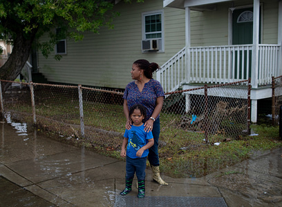 Residents of New Orleans walks through flooded streets following a flash flood that put parts of the city underwater on Wednesday. With the Mississippi River's water level at an all time high and a storm forming in the Gulf of Mexico that is expected to make landfall on the Louisiana and Texas coasts, many fear that levees will fail and that New Orleans will again be inundated as bad as it was in the 2004 aftermath of Hurricane Kartina.