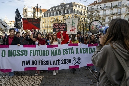 Activists hold placards and a banner with environmental messages are seen shouting slogans during the demonstration. The Climáximo and Student Climate Strike movements, which are fighting to end fossil fuels and promote a more environmentally friendly future, began this protest and march in Largo Camões and ended in front of the Assembly of the Republic in Lisbon, where the next steps in the fight against pollutants will soon be debated in a popular assembly.