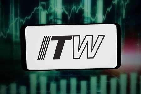 In this photo illustration, the logo of US company Illinois Tool Works Inc. (ITW) is displayed on a smartphone in front of abstract background on computer screen.