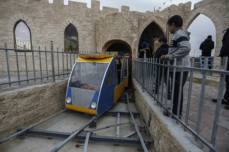 A kid looks at the moving train during the opening.
Palestinians open up an amusement suspension railway dubbed "The Return Train" at the theme park in Khan Yunis.