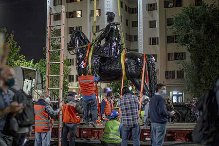 Workers tie the statue on a trailer to be moved to a restoration place.
Chile's National Monuments Authority removes the statue of General Manuel Baquedano, from the plaza Baquedano that bears his name and it's the epicenter of constant social protests.
