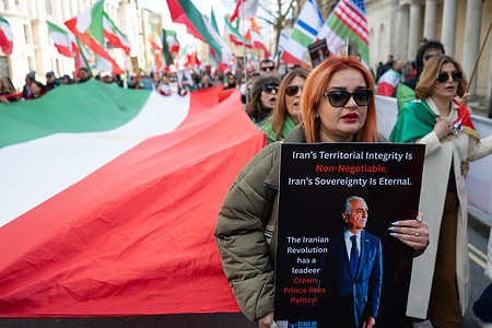 A protester holds a placard reading "Iran's territorial integrity is not negotiable. Iran's sovereignty is not eternal" during the rally. Members of the Iranian diaspora marched past Downing Street in Westminster during a demonstration supporting United States and Israeli military action against Iran and calling for the overthrow of the Islamic Republic. Protesters waved pre-1979 Iranian flags and carried portraits of exiled crown prince Reza Pahlavi, chanting slogans demanding regime change and the restoration of the monarchy in Iran.