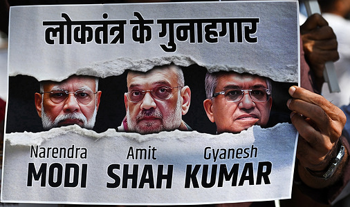 Congress party supporter hold a placard with photos of Indian Prime Minister Narendra Modi (L), Amit Shah (c), Minister of Home Affairs and Gyanesh Kumar (R), Chief Election Commissioner (CEC) of India during a protest demanding resignation of Gyanesh Kumar in Mumbai. Opposition parties are demanding resignation of Gyanesh Kumar, Chief Election Commissioner (CEC) of India over allegation of voter list manipulation during the verification of country's voter population under Special Intensive Revision (SIR) registering eligible citizens as voters and remove duplicate, deceased or incorrectly entered names from existing voter lists.