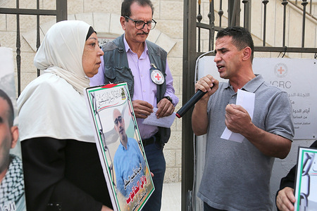 A Palestinian hands over a document to a representative of the International Committee of the Red Cross (ICRC) formally requesting that the ICRC submit an official petition to the Israeli government to authorize prisoner visits. Protesters demand that the ICRC formally calls upon the Israeli government to allow visits to the prisoners given the families' inability to obtain visitation permits since October 7, 2023.