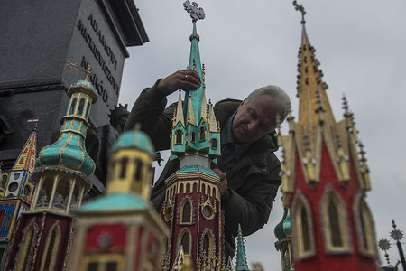 A man glues a tower during the 75th edition of Christmas Cribs competition. The 'cribs' are nativity scenes, but different from those elsewhere in the world – Kraków’s szopki are elaborate compositions built in an architectural, usually church like form, and made in astonishing detail from cardboard, wood, tinfoil and the like.