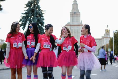 Participants wearing festive pink costumes seen posing for photos during the Pink Run charity event. The 2026 Pink Run became a dynamic sports event that highlights breast cancer awareness and brings together female runners of all levels near Moscow State University.