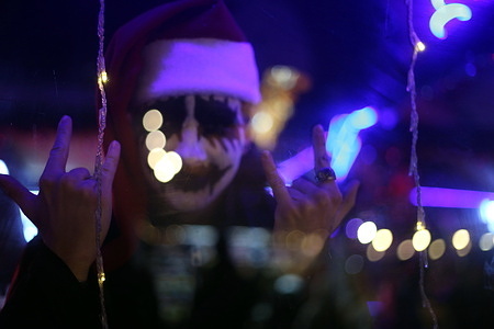 A man in makeup and a Santa hat seen posing for a picture in a cafe on Greek Square. Odessa residents are preparing to celebrate the New Year of 2026 and people are trying to live their normal lives amidst the power shortages and ongoing Russian shelling.