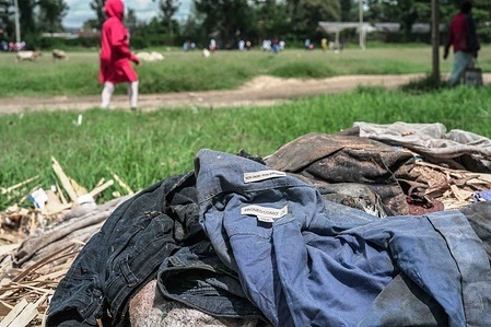 People seen walking past a pile of textile waste dumped besides the road. Rising demand for fast fashion, much of it made from polyester is driving a surge in textile waste shipped to Global South countries like Kenya as second-hand clothing. Much of it is difficult to recycle and ends up polluting the environment, environmentalists now calling for stronger controls on transboundary movement.