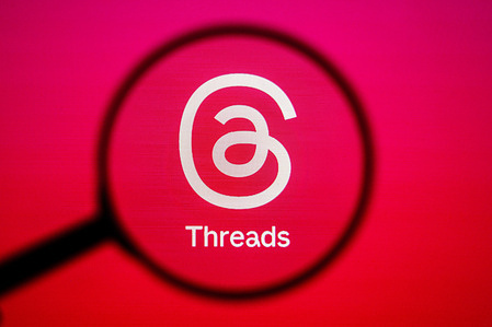 In this photo illustration, a Threads logo seen displayed on a computer screen through a magnifying glass.