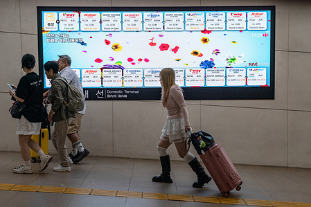 People with luggage pass by the Flight Information Display System (FIDS) at Gimpo International Airport in Seoul. Gimpo International Airport is located in the far western end of Seoul, the capital of South Korea. The name Gimpo comes from the nearby city of Gimpo, of which the airport used to be a part.