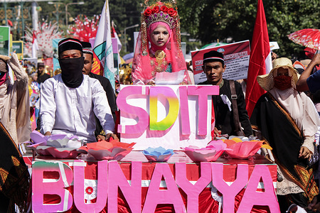 Carnival participants seen dressed in traditional costumes during the event.
Thousands of students and teachers attended a parade in traditional Indonesian clothing to enliven the 73rd Republic of Indonesia Independence Day held every August 17th in the city of Lhokseumwe, Aceh Province, Indonesia.