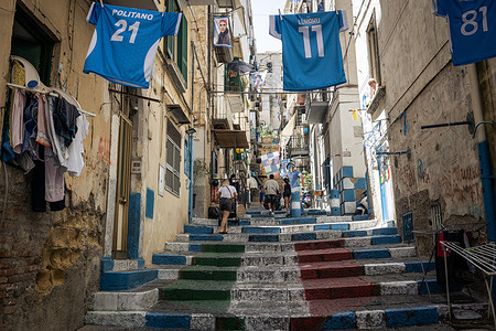 View of a street at the Quartieri Spagnoli with the colours of the Italian flag painted in the staircases and with Naples Football Club shirts hanging.