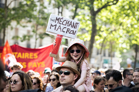 A young girl holds a placard that says "Macron is evil" during a rally on the International Workers Day. More than 150,000 people attended the traditional May Day demonstration. The fight against racism, the far-right and the call for an end to the genocide of the Palestinian people were the central themes of the event.