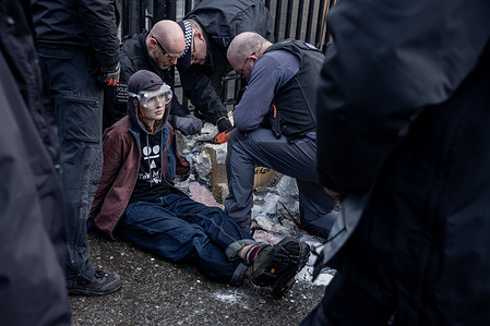 Police use electric chainsaws to separate an anti-Starmer protestor from an papier mache effigy of Keir Starmer. Two young protestors from activist group TAKE BACK POWER glued themselves to a papier mache effigy of Keir Starmer outside Parliament. Calling on Starmer to resign, they had to be sawed out of the sculpture prior to being arrested.