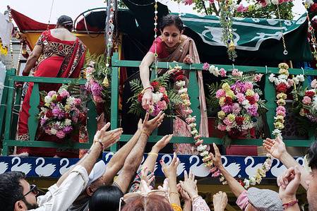 A devotee distributing flowers to the festival goers. The 46th annual Ratha Yatra (Festival of Chariots) began at the intersection of Milton and Saint Laurent Streets, proceeding towards Jeanne-Mance Park for a free vegan feast, live kirtan, and cultural exhibits. The main chariot carried the deities Lord Jagannath, Baladeva, and Subhadra.