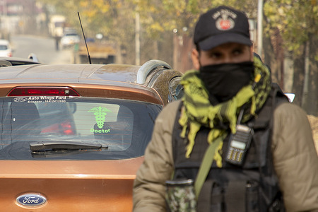 Indian policeman keeps vigil past doctor's car during a surprise operation in south Kashmir following a car explosion near the Red Fort in the capital. High security alerts were deployed in several Indian states that tightened security along international borders with Pakistan, after a powerful car explosion near historic Red Fort in Delhi that killed nine people and injured several. Police identified Dr Mohammad Umar, as the prime suspect.