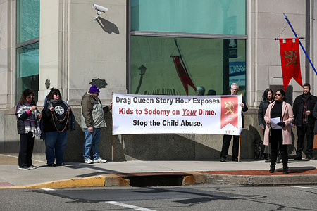 Protesters with a banner pray across the street from the theater while the sold-out drag BINGO event was taking place several miles away at the Nescopeck Township Fire Company. People from The American Society for the Defense of Tradition, Family, and Property protest a drag BINGO fundraiser for the Berwick Theater and Center for Community Arts.