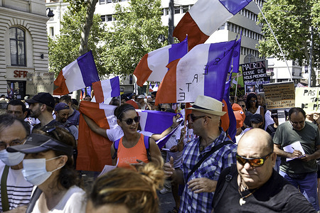 Protesters hold flags during the demonstration against the health pass in Marseille.Thousands of people demonstrate against the health pass in Marseille, France. French President Emmanuel Macron announced among new anti-Covid 19 measures a "health pass" which will be necessary to be frequenting café terraces, restaurants, cinemas, theatres and other culture and leisure activities to help contain the spread of the Covid-19 virus.