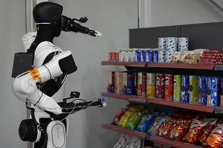 Robots simulate working on small supermarket shelves during the 2026 World Humanoid Robot Games.
