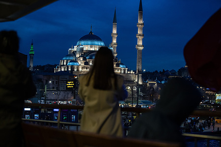 In the evening hours, the silhouettes of city ferry passengers seen visible together with the new Mosque in the background.