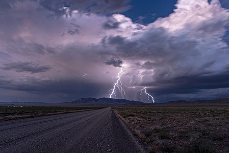 Lightning strikes on a dirt road leading to the Nevada Test and Training Range, which houses the classified military facility known as Area 51 in Rachel. Nearby along the famous Extraterrestrial Highway sits Rachel, a small and iconic desert enclave. Known far and wide as the "UFO Capital of the World," this quirky town is world-famous among sky-watchers and road-trippers for its close proximity to the restricted Area 51 facility.