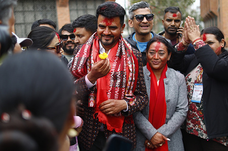 Rastriya Swatantra Party (RSP) candidate Rajiv Khatri receives a flower from a supporter after winning the Bhaktapur-2 seat in the House of Representatives election defeating CPN-UML heavyweight Mahesh Basnet.