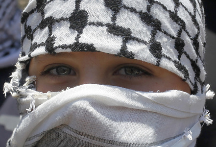 A masked Palestinian protester seen, during the demonstration against Israeli settlements in the village of Kafr Qaddoum near the West Bank city of Nablus.