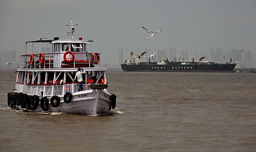 LPG tanker 'Jag Vasant' (background) is seen anchored at Mumbai port after crossing Strait of Hormuz. Indian ships carrying crude oil, LPG and LNG were struck at Strait of Hormuz due to ongoing war between US-Iran-Israel. Indian government is ensuring that Indian flagged vessels are allowed to pass safely amidst the ongoing tension in Gulf region.