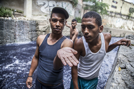 Hector and Jose have been working together for two years looking for earrings, rings and other small jewels at the bottom of the dirty river Guaire.
People of low income get into the waters of the Guaire River in Caracas to search for valuables. The waters of this river transport bacteria and all the waste of the city. They get into the water to try their luck and see if they find traces of gold pieces of clothing or jewellery objects that have fallen through the sinks of the houses of the wealthy people.
