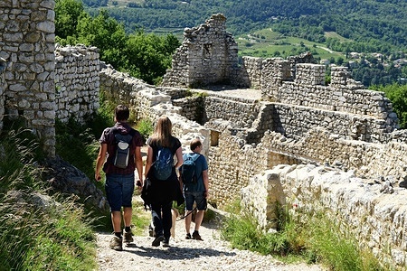 Hikers seen at Crussol Castle. Medieval fortress is from the early 12th century located in the commune of the Auvergne-Rhône-Alpes region.