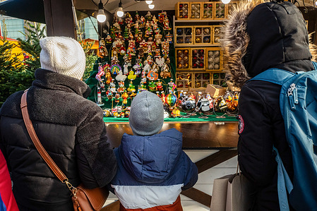 A family looks at what is on offer from one of the many stalls. On the 28th of November, the city of Warsaw opens its new Christmas Market (Jarmark Warszawski) at Plac Defilad (next to the Palace of Culture and Science). The market runs for over a month, open daily until Thursday, the 1st of January, 2026. Visitors can enjoy over 150 wooden cottage stalls, an open-air cinema, Poland's largest Big Wheel, rides, attractions, and light sculptures, not to mention a wide array of festive foods and mulled wine.