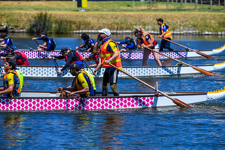 Close finish by three boats is seen at Lunar New Year Regatta Dragon Boat Racing hosted by Dragon Boat Racing Victoria on Bawron River in Geelong, Australia.
