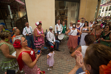 A group of women dance and others play instruments on the street dressed in traditional flamenco clothes as they take part in the 2023 Malaga Fair. Thousands of people gathered in the city's main streets to take part in the Malaga Fair in a festive atmosphere. Over the course of a week, thousands of tourists and locals will enjoy concerts, flamenco dancing in the streets and other activities such as the bullfighting fair and horse shows.