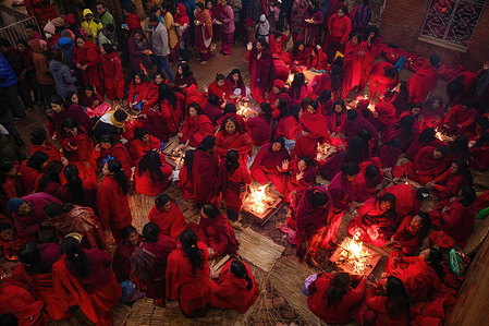 Nepalese Hindu women warm themselves before taking a holy bath in Salinadi River during the first day of Madhav Narayan Festival, in Sankhu. The month-long festival, dedicated to God Madhavnarayan and Goddess Swasthani, involves the recitation of folk tales about miraculous feats performed by them in many Hindu households.