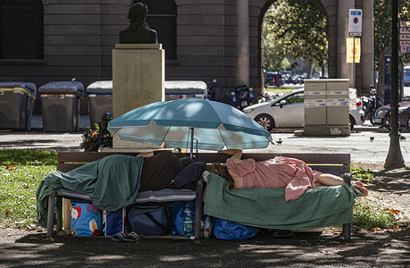 An older homeless couple is seen sleeping alongside their belongings on a public bench in Barcelona's Pla de Palau square. The lack of social housing is one of the most pressing issues facing the city of Barcelona. The Arrels Foundation estimates that there are 2,000 people living on the streets of Barcelona in 2026.