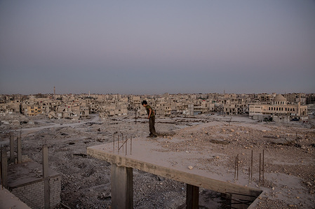 Yusuf (12) looks off the edge of the top of a destroyed building in Tadamon, a neighbourhood in Syrian capital Damascus. Human bones are still being found in Tadamon, the site of an infamous 2013 massacre, months after the Assad regime fell.