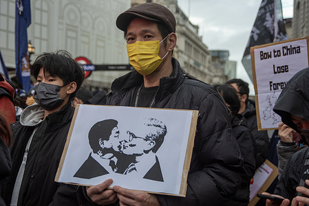 A protester holds a sign with the kissing Keir Starmer (R) and Xi Jinping (L) on it during the demonstration on the Piccadilly Circus. Hong Kongers, Taiwanese and Tibetans protest on the Piccadilly Circus against the planned Chinese mega-embassy. The proposed controversial new embassy is going to be located near the Tower Bridge at the Royal Mint Court.